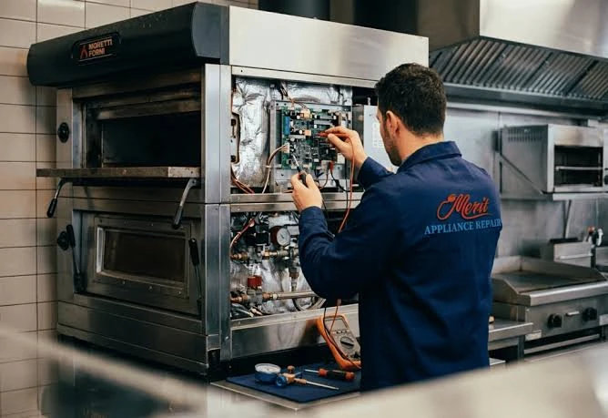 Technician testing the electrical components of a commercial oven